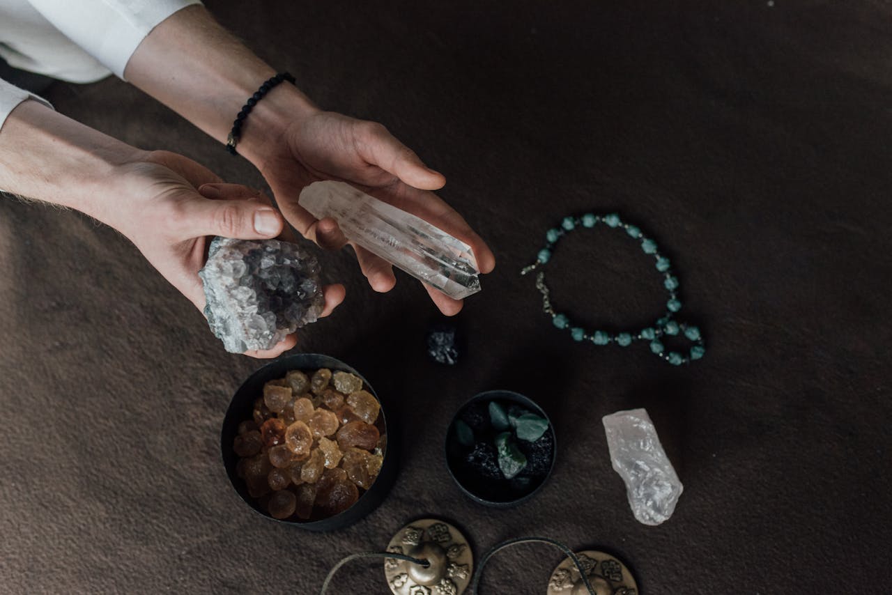 Close-up of hands holding various healing crystals for alternative therapy and meditation.